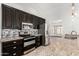 Well-equipped kitchen features stainless appliances, dark wood cabinetry, granite countertops, and neutral tile flooring at 647 W Mission Dr, Chandler, AZ 85225