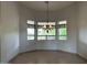 Bright dining area with three windows, chandelier, and tile flooring offering an elegant and airy ambiance at 694 W Beechnut Dr, Chandler, AZ 85248