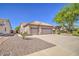 Side view of a beige single-story house, featuring a three-car garage, desert landscaping, and a tile roof at 694 W Beechnut Dr, Chandler, AZ 85248
