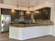 Modern kitchen featuring stainless steel appliances, granite countertops, stylish pendant lighting, and sleek gray cabinetry at 694 W Beechnut Dr, Chandler, AZ 85248