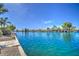 Scenic view of a tranquil lake surrounded by beautiful homes and lush greenery under a clear blue sky at 694 W Beechnut Dr, Chandler, AZ 85248