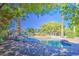 Inviting backyard pool area with stepping stone details, lush landscaping, mature trees, and a small water feature at 694 W Beechnut Dr, Chandler, AZ 85248