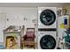 Convenient laundry area with stacked washer and dryer, utility sink and chair at 7246 E Virginia Ave, Scottsdale, AZ 85257
