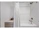 The white tiled shower over tub has a rainfall shower head and convenient shelving at 7246 E Virginia Ave, Scottsdale, AZ 85257