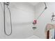 Modern shower with sleek, white tile, a rainfall shower head, and convenient built-in shelving at 7246 E Virginia Ave, Scottsdale, AZ 85257