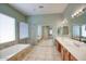 Bathroom featuring double sinks, large mirror, walk-in shower, and separate soaking tub at 8068 W Carlota Ln, Peoria, AZ 85383