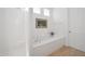 Clean and well-lit bathroom features a built-in tub and shower behind a half-wall, with a window at 8541 E Krail St, Scottsdale, AZ 85250