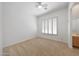 Simple bedroom featuring neutral walls, carpet, a ceiling fan, and a window with shutters at 8541 E Krail St, Scottsdale, AZ 85250