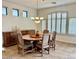 Formal dining room with a wood table, six chairs, chandelier, and a wood console table at 8541 E Krail St, Scottsdale, AZ 85250