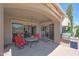 Inviting covered patio boasts red chairs, a BBQ grill, and outdoor access at 8541 E Krail St, Scottsdale, AZ 85250