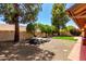 Well-maintained backyard featuring mature trees, gravel landscaping, and a charming rock water feature at 9645 W Kimberly Way, Peoria, AZ 85382