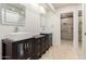 Bathroom with dual sinks, dark cabinets, framed mirrors, and a glass-enclosed shower at 9645 W Kimberly Way, Peoria, AZ 85382