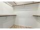 Bright walk-in closet with built-in shelving and warm-toned tile flooring at 9645 W Kimberly Way, Peoria, AZ 85382
