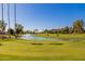 Scenic view of the golf course featuring lush green grass, a water hazard with a fountain, and mature trees at 9645 W Kimberly Way, Peoria, AZ 85382
