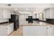 Modern kitchen with white cabinets, granite countertops, and a black backsplash at 9645 W Kimberly Way, Peoria, AZ 85382