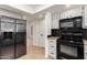 This kitchen features stainless steel appliances and white cabinets with a black mosaic backsplash at 9645 W Kimberly Way, Peoria, AZ 85382