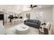 Bright living room with an open-concept kitchen and a modern gray sofa at 9645 W Kimberly Way, Peoria, AZ 85382