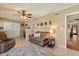 Cozy living room with a leather sofa, ceiling fan, and tile flooring at 9666 W Mountain View Rd # A, Peoria, AZ 85345