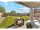 Cozy covered patio with an armchair overlooking the beautifully landscaped backyard at 10252 E Butherus Dr, Scottsdale, AZ 85255