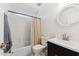 Bright bathroom featuring a round mirror, shower-tub combo, and sleek fixtures at 10252 E Butherus Dr, Scottsdale, AZ 85255