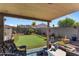 Relaxing backyard featuring a putting green and covered patio with comfortable seating at 1057 E Silversmith Trl, San Tan Valley, AZ 85143