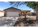 Charming single-story home featuring a two-car garage, front porch, and desert landscaping at 1057 E Silversmith Trl, San Tan Valley, AZ 85143
