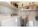 Laundry room with front-loading washer and dryer and built-in shelves at 1057 E Silversmith Trl, San Tan Valley, AZ 85143
