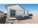 Charming back patio area with a covered seating, minimalist landscaping, and a neutral color palette creating a serene outdoor space at 12438 E Verbina Ln, Florence, AZ 85132
