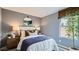 Cozy bedroom featuring a comfortable bed with stylish throw pillows, bedside tables, lamps, and a window with a woven shade at 12469 E Verbina Ln, Florence, AZ 85132