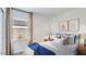 Bright bedroom featuring large window with blinds, neutral walls, minimalist decor, and a comfortable bed with accent pillows at 12469 E Verbina Ln, Florence, AZ 85132