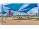 Community playground featuring swings, slides, and climbing structures under shaded canopy at 12469 E Verbina Ln, Florence, AZ 85132