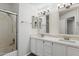 Bathroom featuring double sinks, quartz counters and a shower-tub combo with glass door at 12935 E Mercer Ln, Scottsdale, AZ 85259