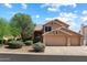 Charming two-story home featuring a three-car garage and a beautifully landscaped front yard at 12935 E Mercer Ln, Scottsdale, AZ 85259