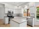 A modern kitchen features stainless steel appliances, a center island, and a large window with a view at 12935 E Mercer Ln, Scottsdale, AZ 85259
