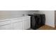 Bright laundry area with modern black washer and dryer set and white cabinetry at 12935 E Mercer Ln, Scottsdale, AZ 85259