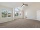 A spacious main bedroom boasts large windows, a ceiling fan, and an attached bathroom at 12935 E Mercer Ln, Scottsdale, AZ 85259