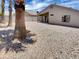 Spacious backyard featuring desert landscaping, a covered patio, and clear blue sky at 13030 W Hearn Rd, El Mirage, AZ 85335