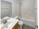 Clean bathroom featuring a tub/shower combo, white tile, and single sink vanity with wood cabinets at 13030 W Hearn Rd, El Mirage, AZ 85335