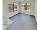Bright dining room featuring wood flooring and views of the neighborhood through large windows at 13030 W Hearn Rd, El Mirage, AZ 85335