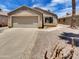 Charming single-story home with a two-car garage, neutral stucco, concrete driveway, and desert landscaping at 13030 W Hearn Rd, El Mirage, AZ 85335
