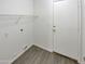 Interior laundry room features wood flooring, a wire rack, and a white door to the exterior at 13030 W Hearn Rd, El Mirage, AZ 85335