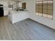 Open living area with wood flooring, granite countertops, and views to the kitchen at 13030 W Hearn Rd, El Mirage, AZ 85335