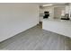 Bright open floor plan features wood flooring and seamless flow into kitchen with granite counters at 13030 W Hearn Rd, El Mirage, AZ 85335
