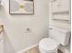 Bright bathroom featuring a toilet with a white tank and modern art piece at 1600 N Saba St # 214, Chandler, AZ 85225