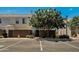 A yellow townhome featuring a privacy fence and mature landscaping in front of parking spaces at 1600 N Saba St # 214, Chandler, AZ 85225