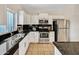 Updated kitchen featuring granite counters, stainless steel appliances, and white cabinets at 1600 N Saba St # 214, Chandler, AZ 85225