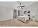 Spacious bedroom features neutral walls, carpet, ceiling fan and art pieces at 1600 N Saba St # 214, Chandler, AZ 85225