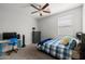 Bright bedroom featuring blue accents, ceiling fan, large window and plush carpeting at 17038 W Mohave St, Goodyear, AZ 85338