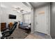 Open bedroom with ceiling fan, flat-screen tv, desk, and an exterior door at 17038 W Mohave St, Goodyear, AZ 85338