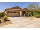 Lovely home showcasing a neat driveway, two car garage, and manicured landscaping at 17038 W Mohave St, Goodyear, AZ 85338
